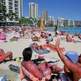 Эрэг дээр биеэ наранд шарагчид