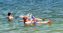 Сөнөсөн тэнгис усанд орж буй хүмүүс